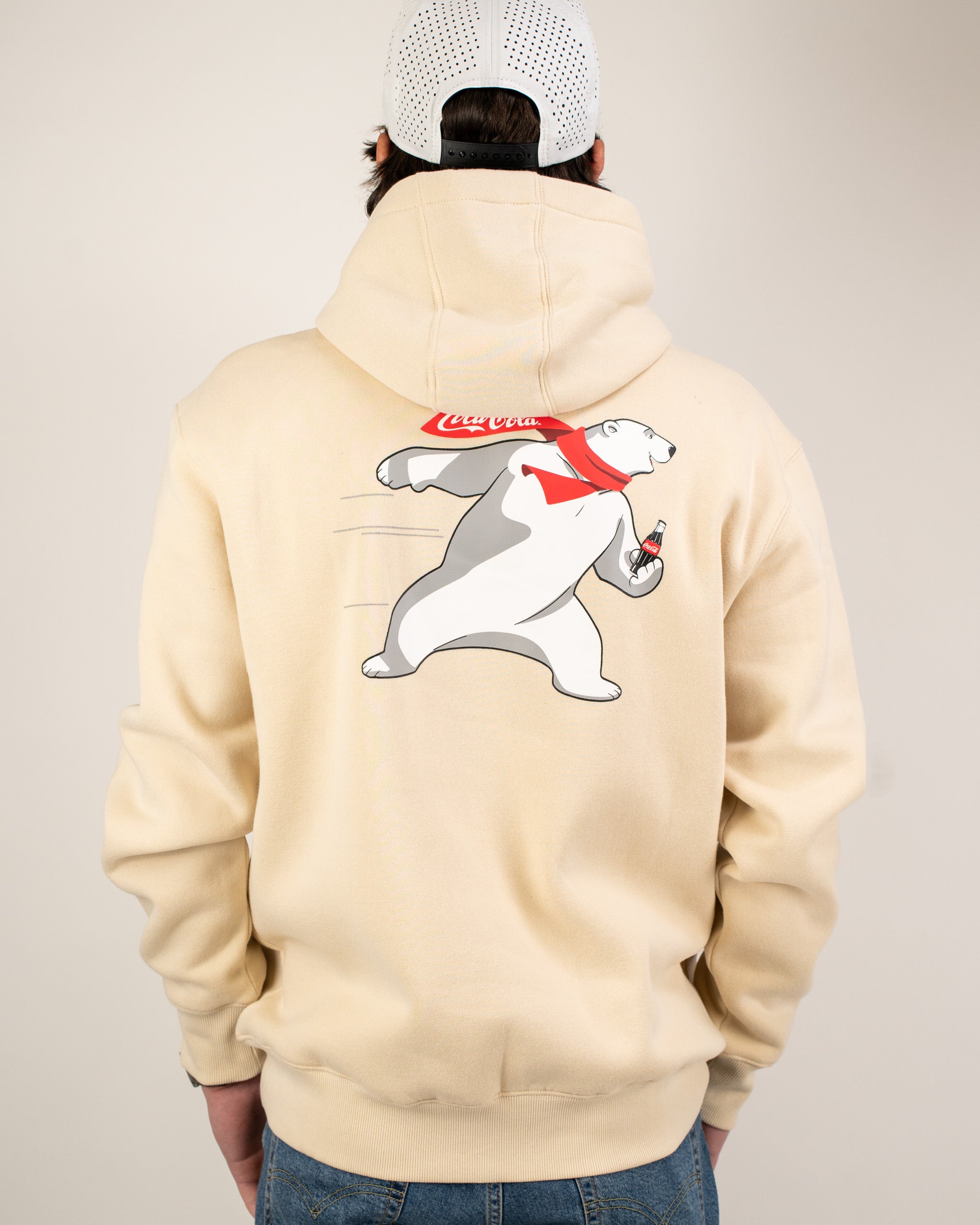 Cream hoodie featuring a playful polar bear graphic holding a Coca-Cola bottle on the back. Perfect for casual wear.