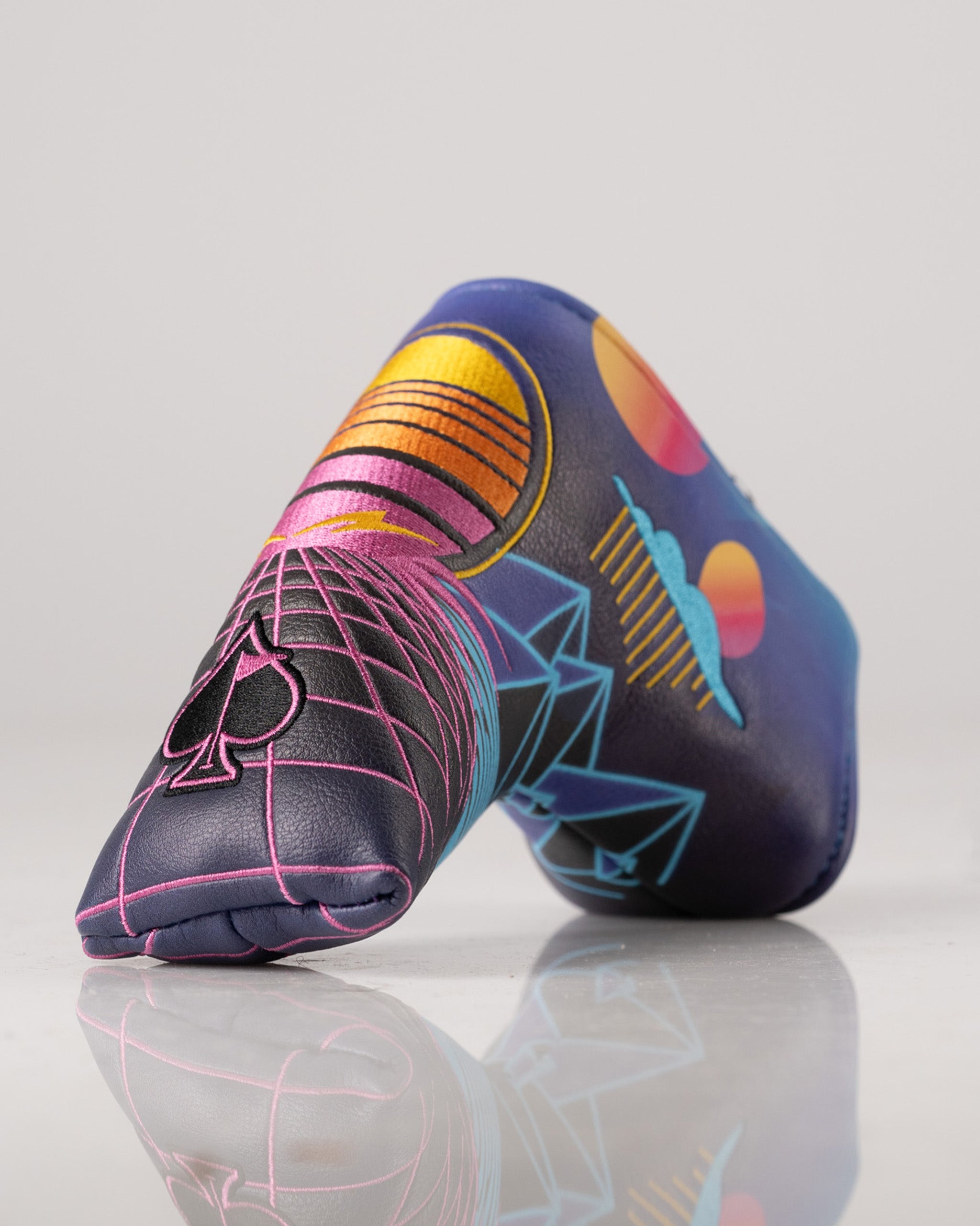 Vibrant Synthwave Blade Putter Cover featuring retro graphics of geometric shapes and colorful sunsets, perfect for stylish golfers.