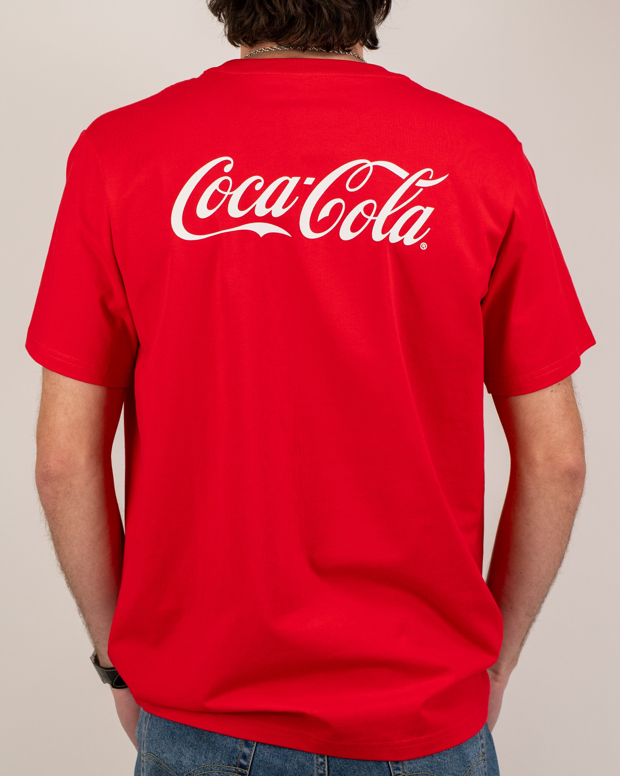 Red Coca-Cola tee shirt featuring the iconic logo prominently displayed on the back, perfect for casual wear.