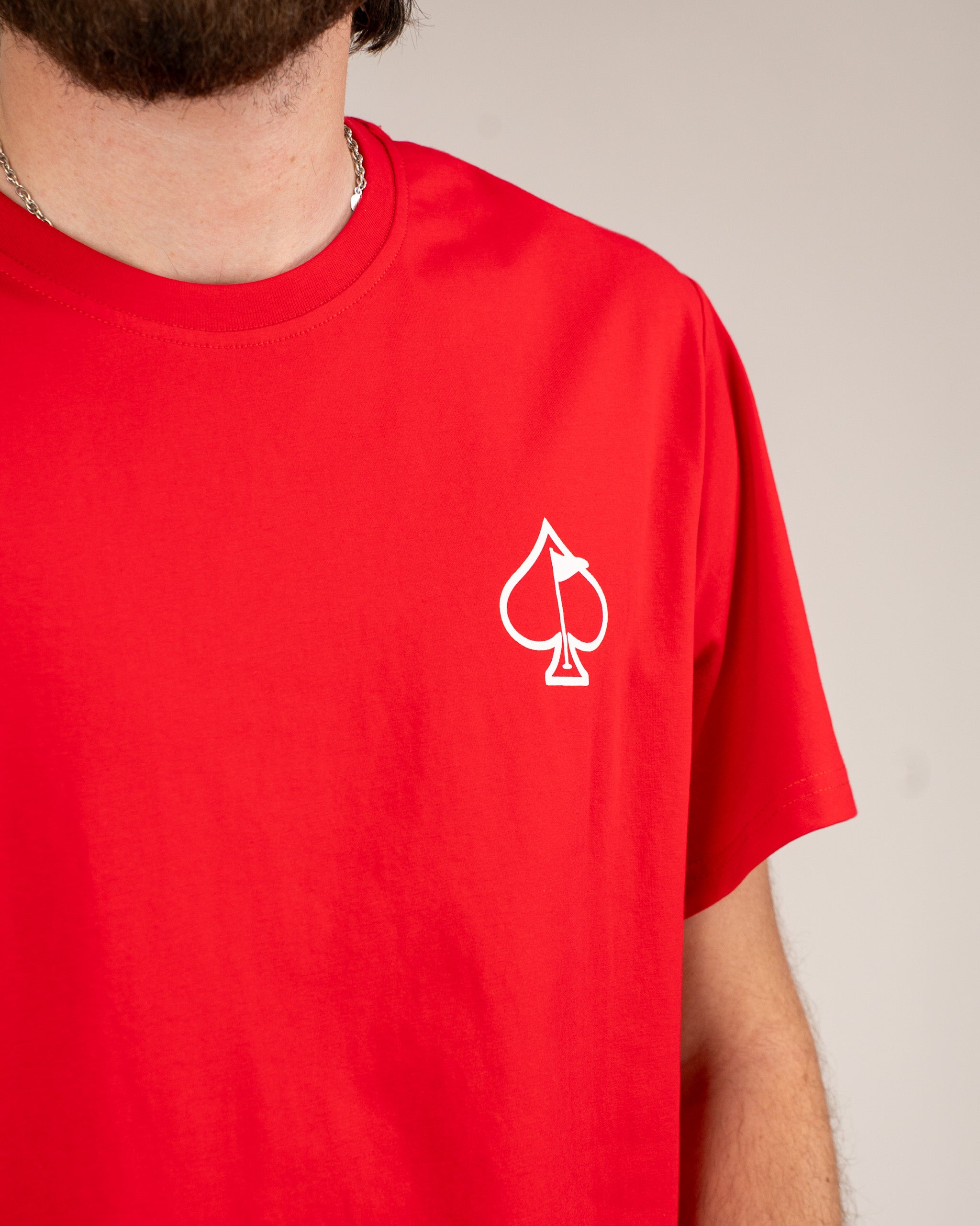 Bold red tee shirt featuring a white spade logo, perfect for making a statement on and off the golf course.