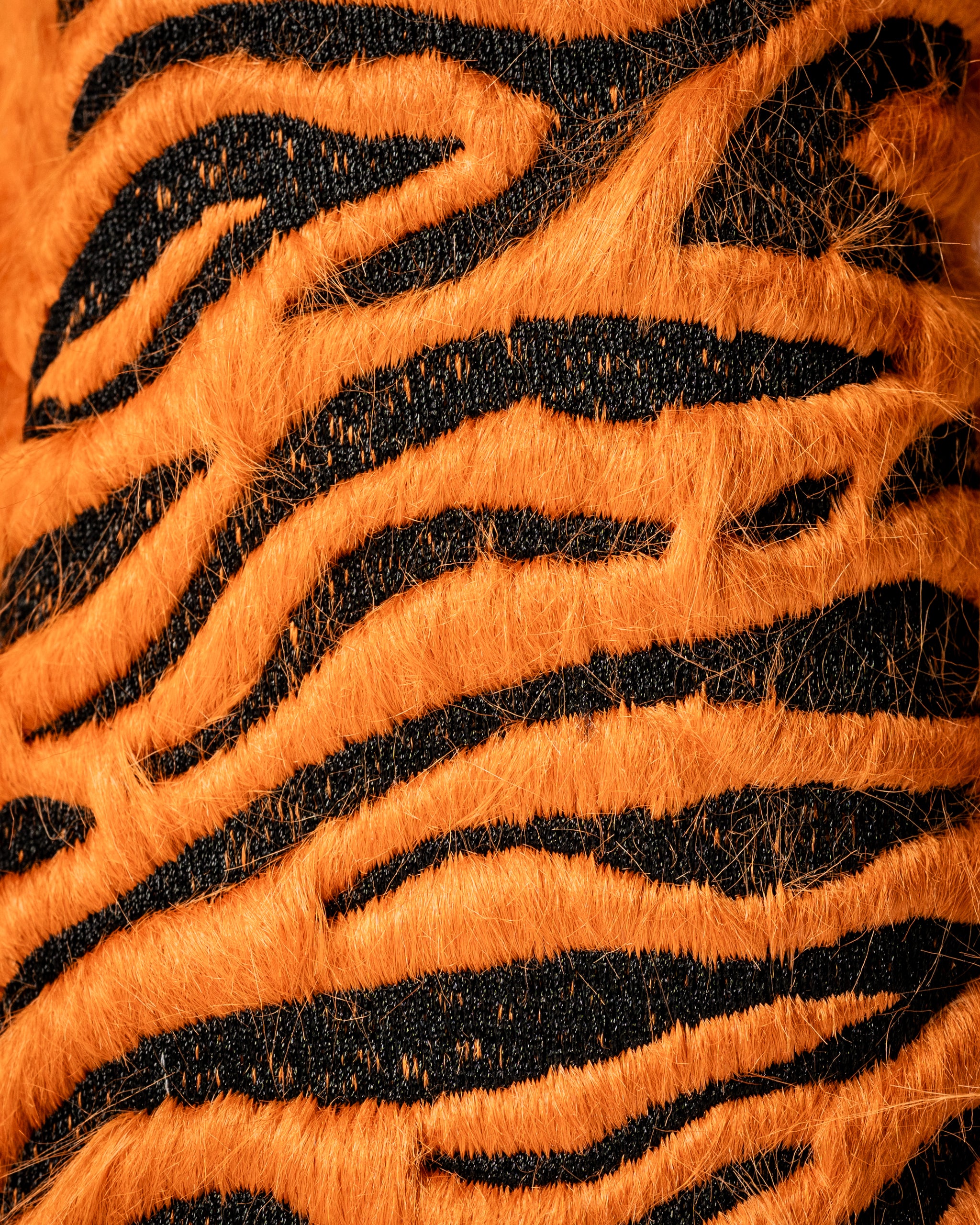 Bold orange and black tiger-striped headcover set designed to add a unique flair to golf clubs on the course.