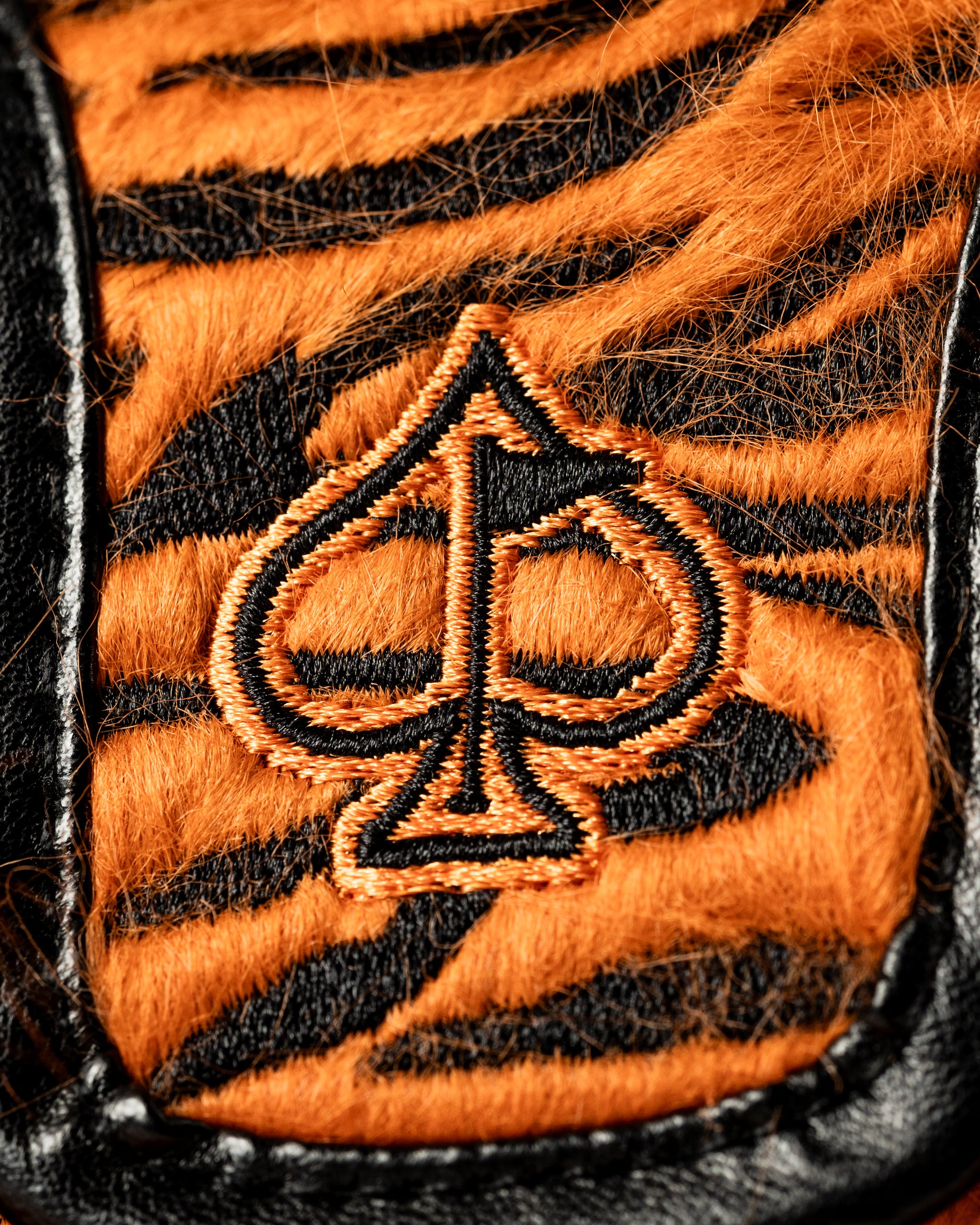 Bold mallet putter cover featuring a striking tiger stripe design and an embroidered spade logo for standout style on the course.