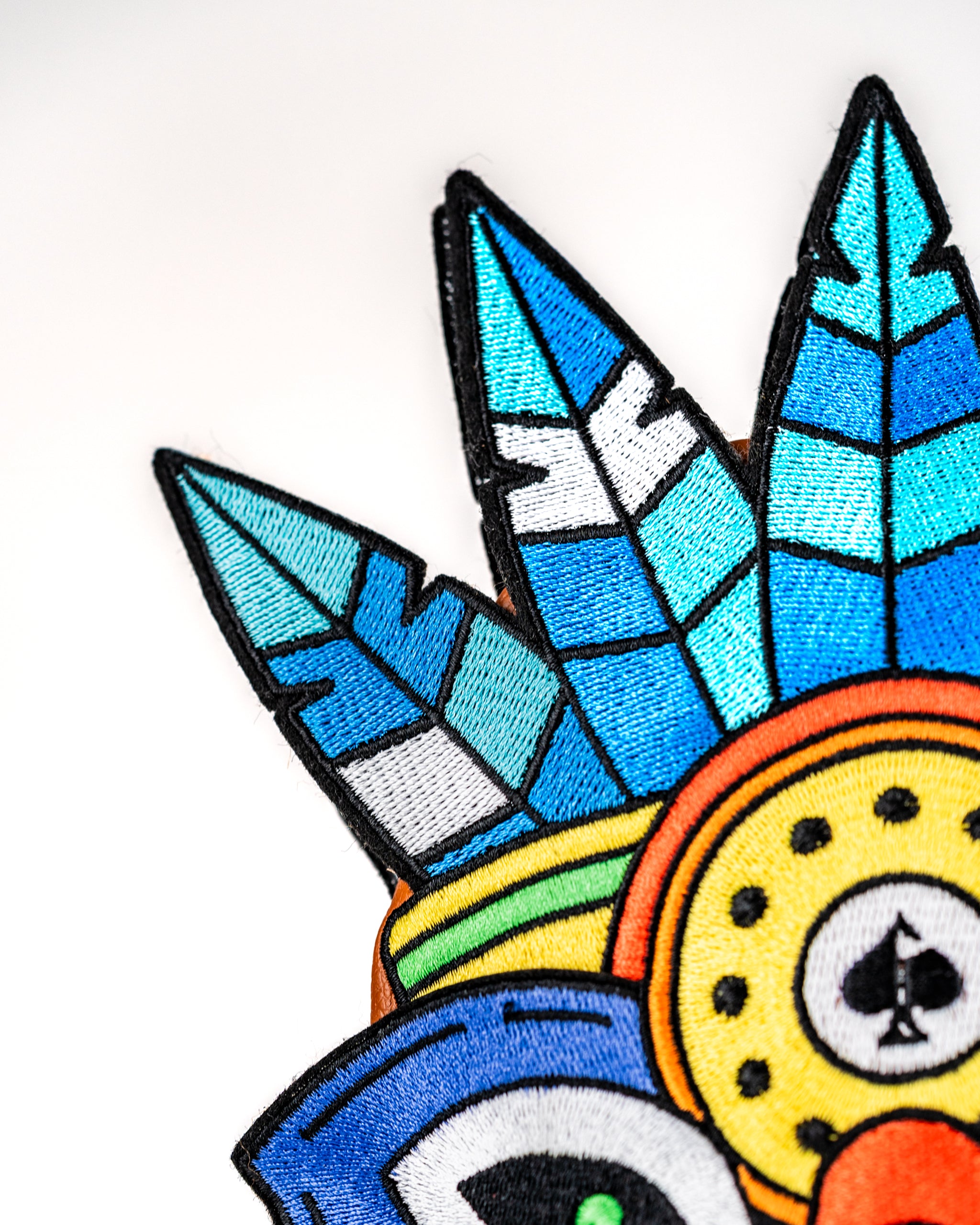 Colorful Tiki hybrid golf club cover featuring intricate embroidery with feathers and a playful design.