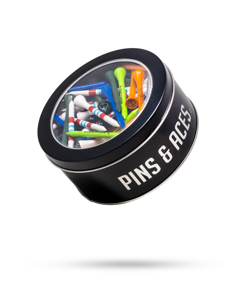 Black tin labeled "PINS & ACCESSORIES" filled with colorful golf tees and accessories, viewed from above against a white background.