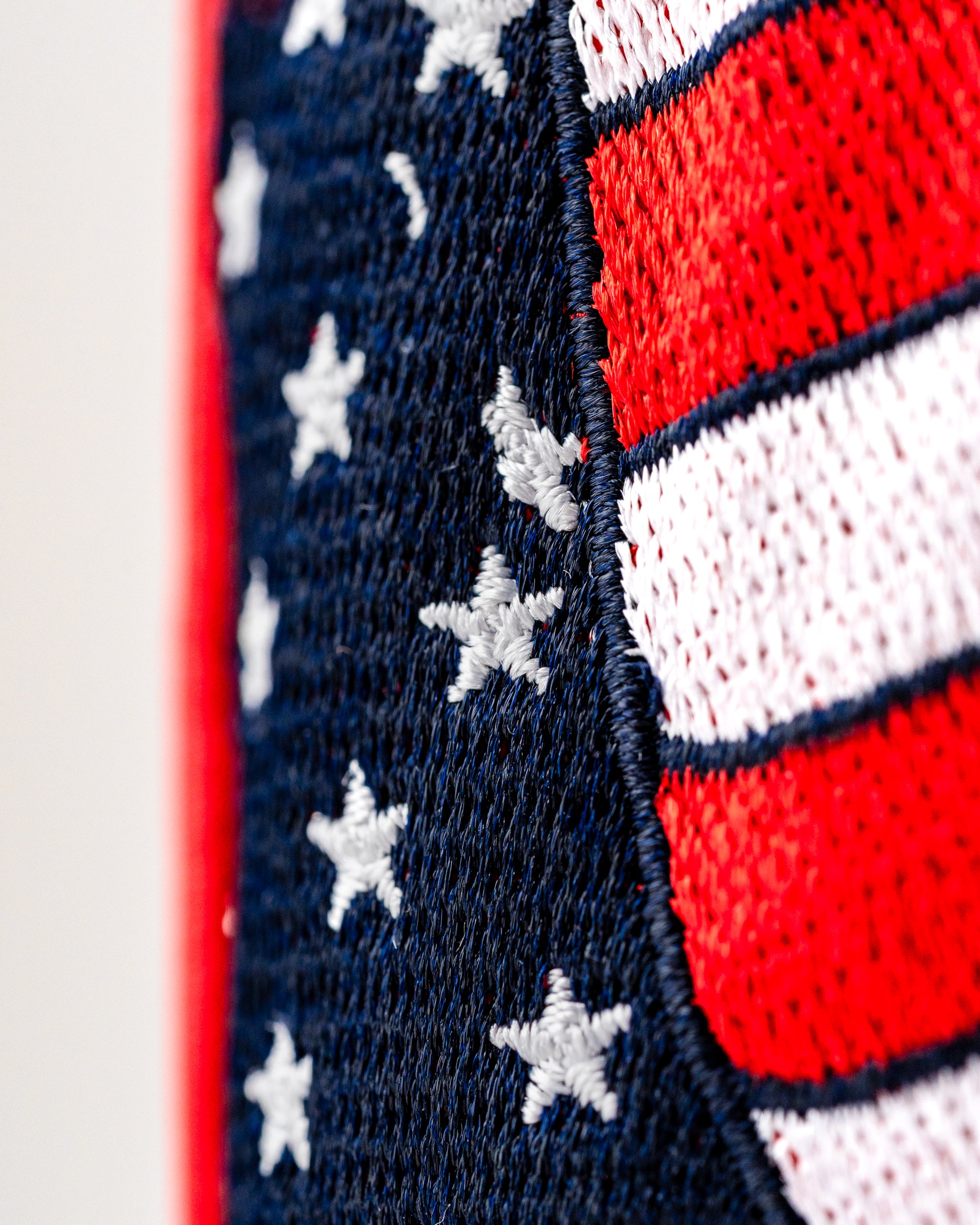 Close-up of a golf fairway cover featuring a patriotic design with red, white, and blue colors and star patterns.