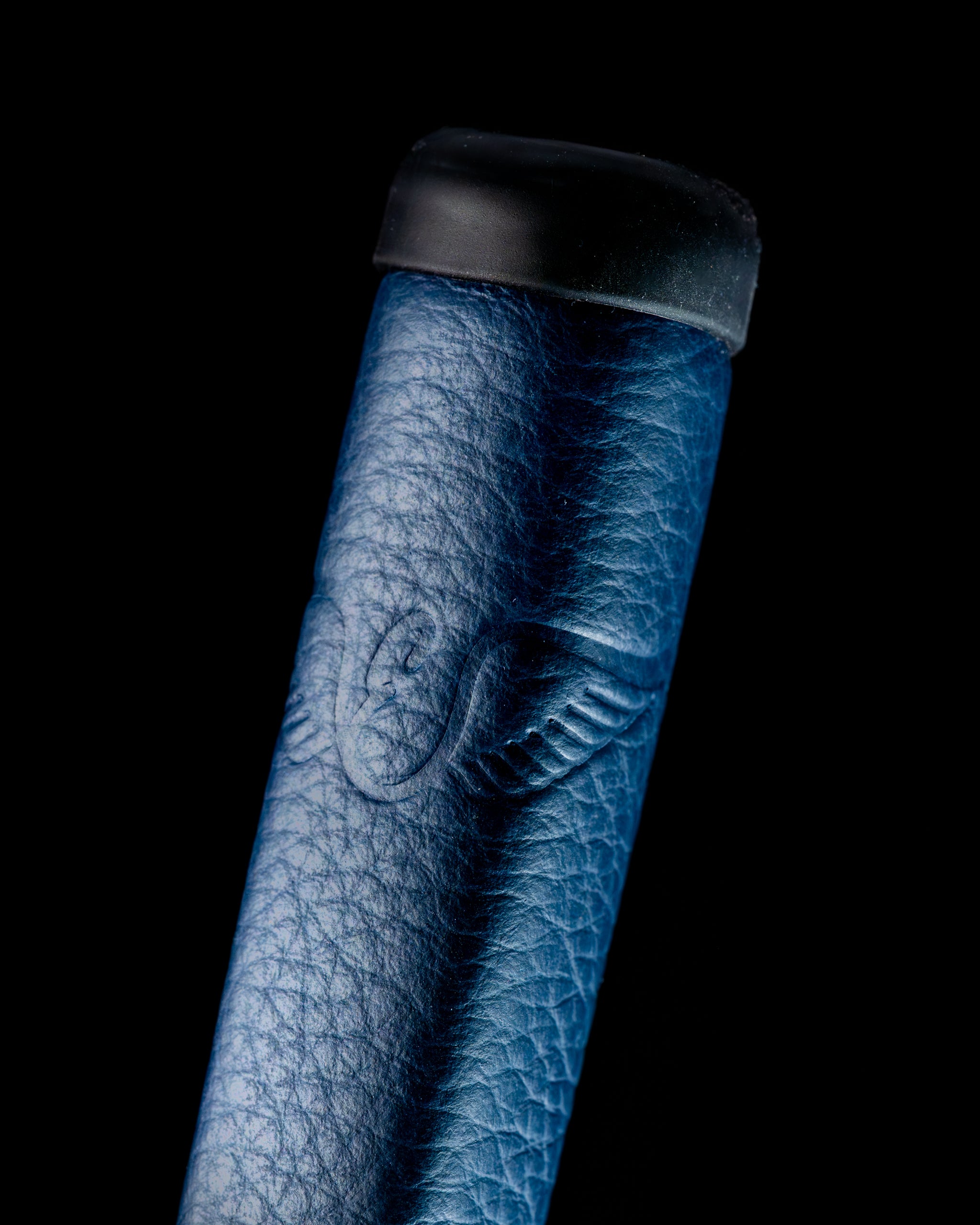 Close-up of the Edel Twister Putter grip, featuring a textured blue leather design with a winged logo at the top.