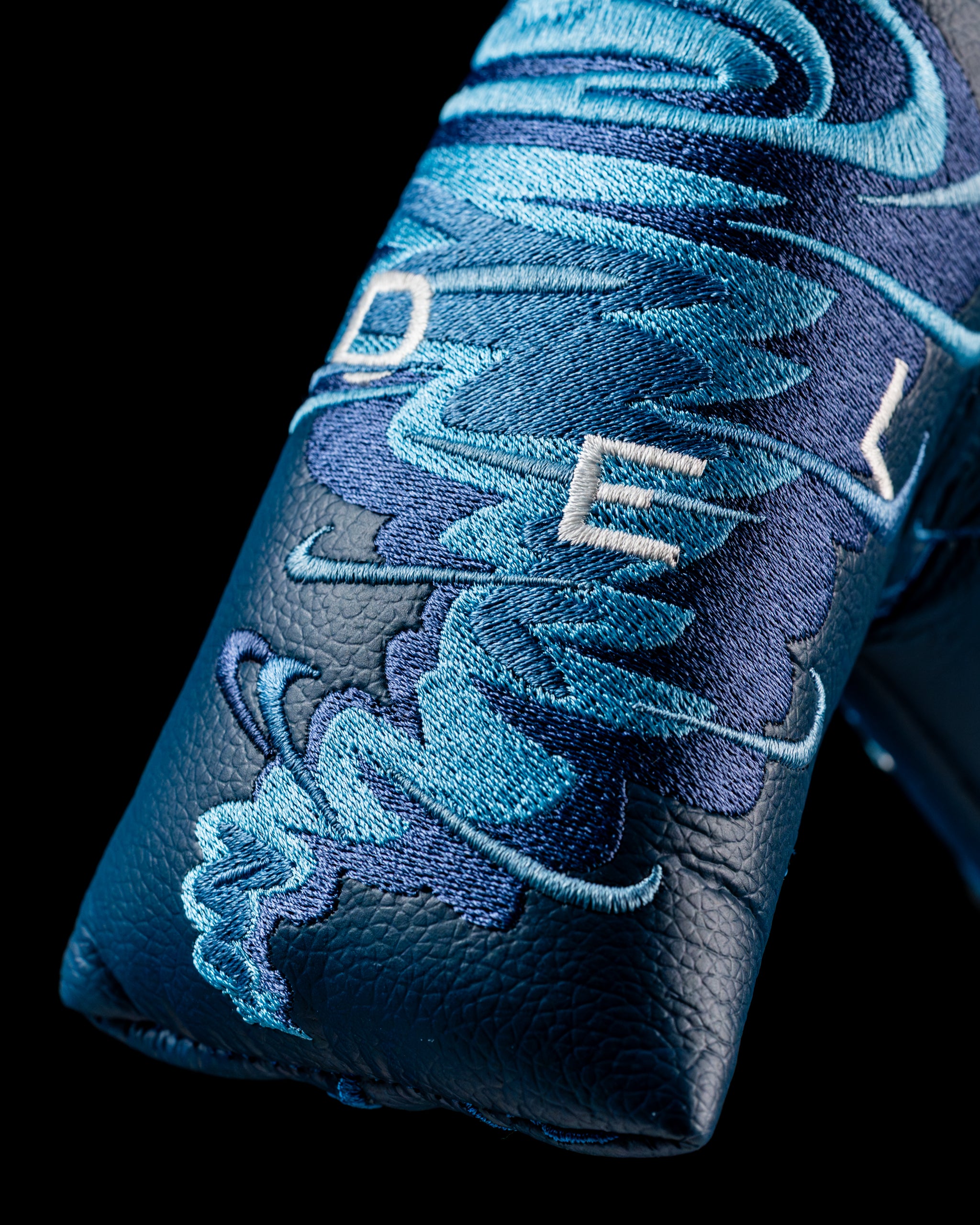 Edel Twister Putter headcover featuring a swirling blue design with embroidered "EDEL" lettering on a dark background.