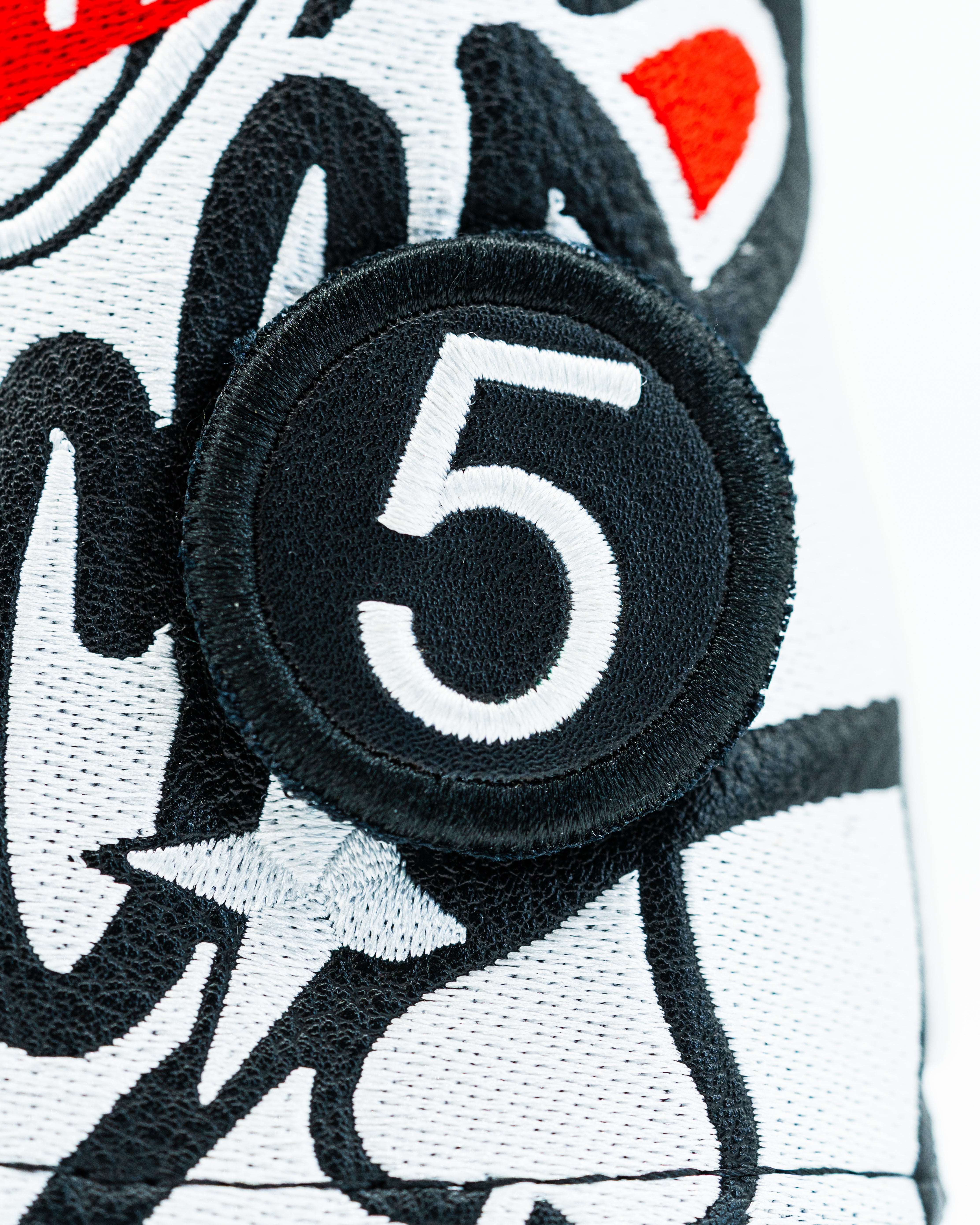 Black headcover patch featuring a bold white number five, designed for stylish golf accessories.