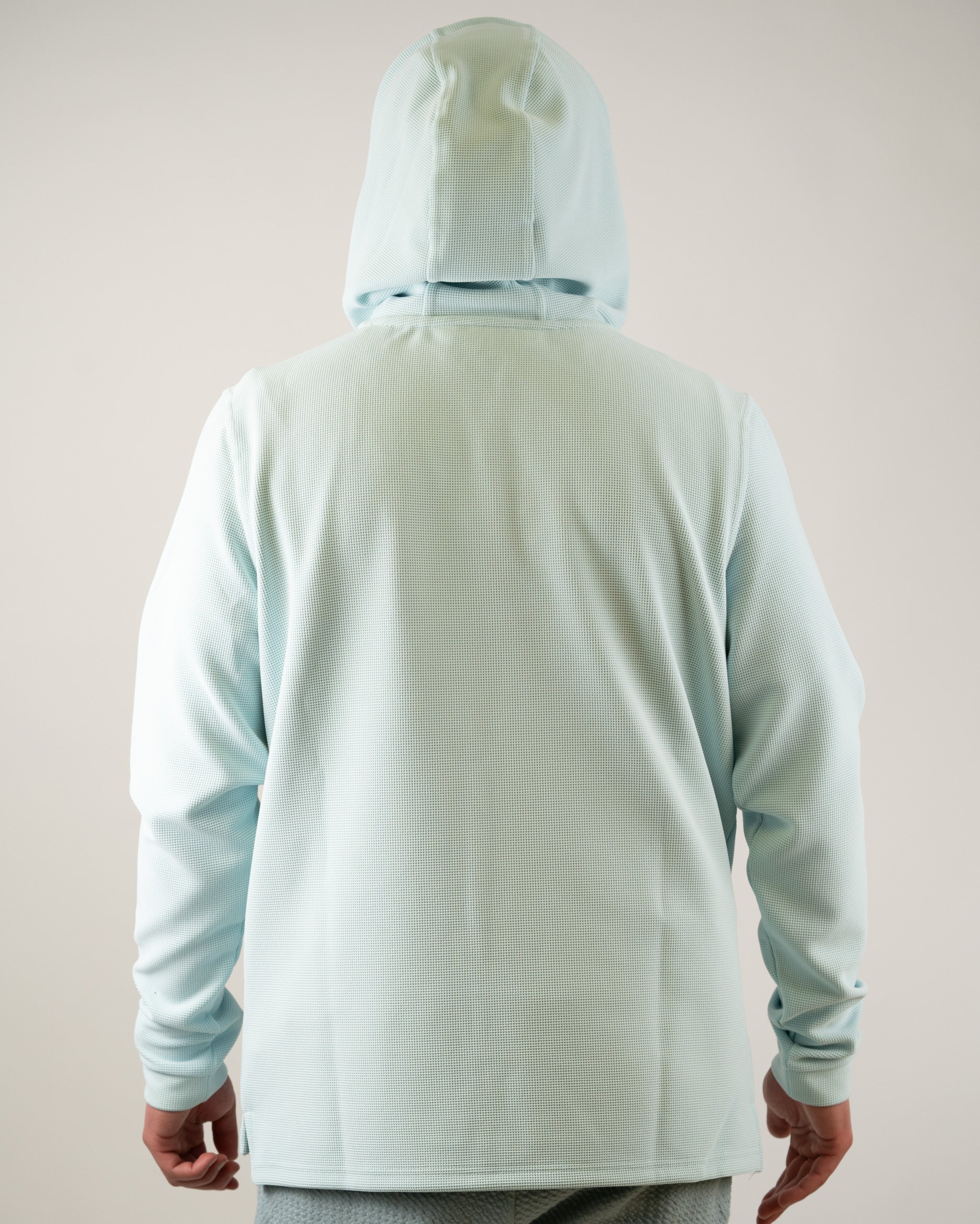 Back view of the Player Preferred Waffle Grid Hoodie in Ice Blue, featuring a relaxed fit and hood. Ideal for stylish golf wear.