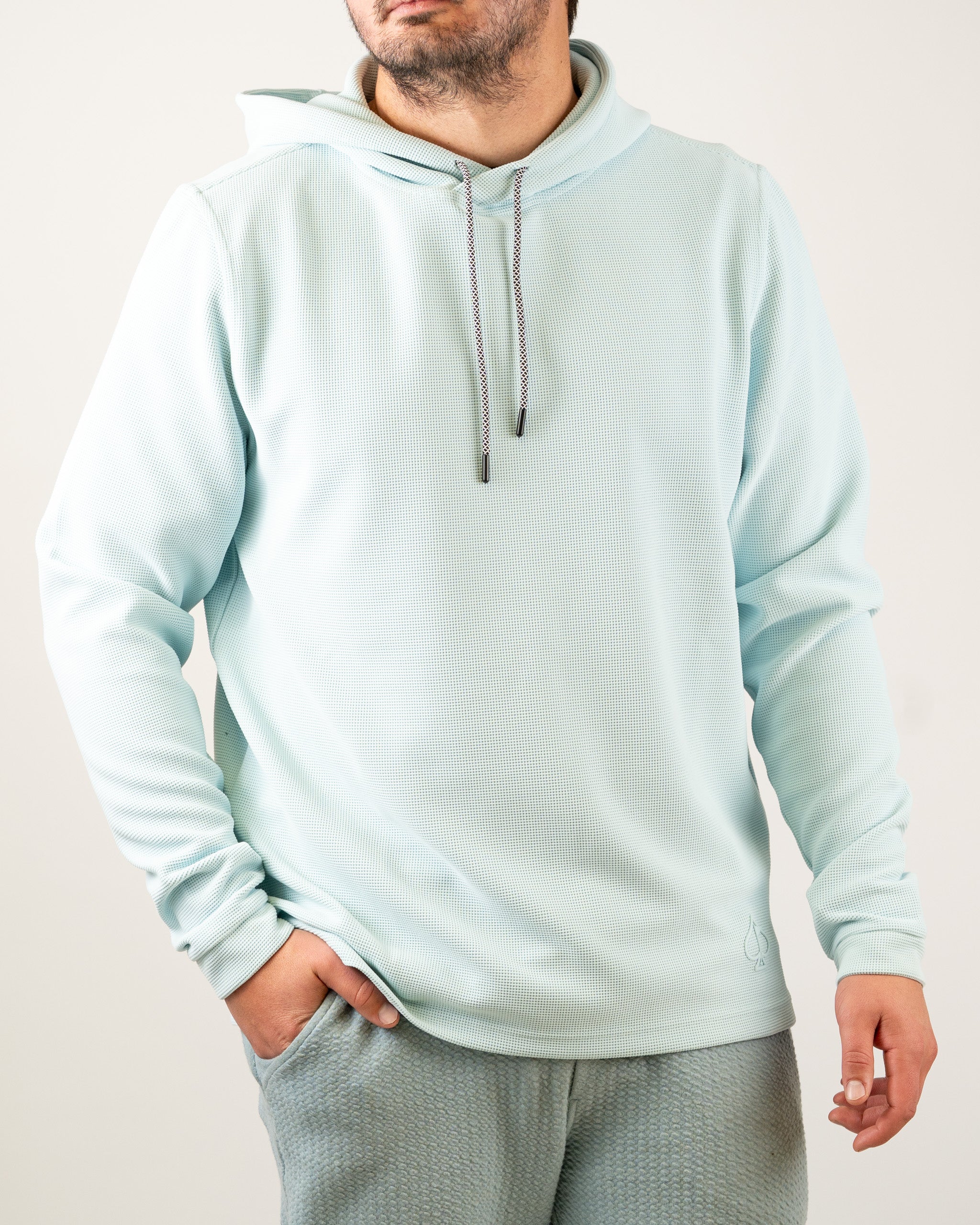 Light blue waffle grid hoodie with a drawstring hood, featuring a relaxed fit and stylish design for golfers.