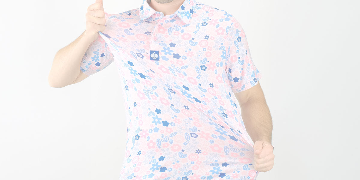 Man wearing a pastel pink and blue floral golf polo shirt, emphasizing bold, unique golf apparel for standout course style.